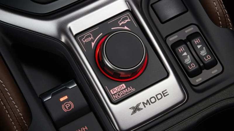 Close-up of a Subaru X-MODE control dial and heated seat switches in a car interior.