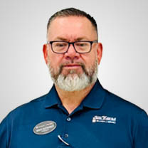 Middle-aged man with a gray beard and glasses wearing a blue polo shirt.