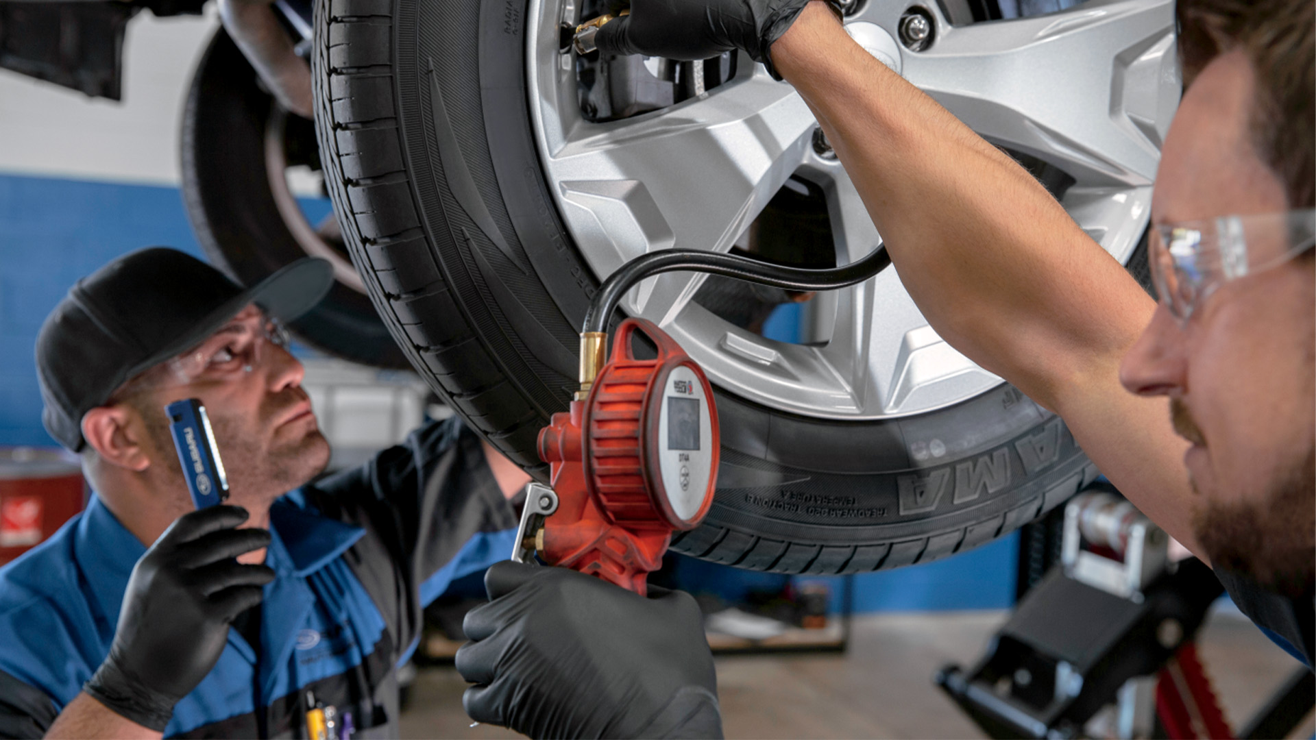 A clean service bay at Sunset Hills Subaru where a 2019 Ascent is receiving a tire rotation.