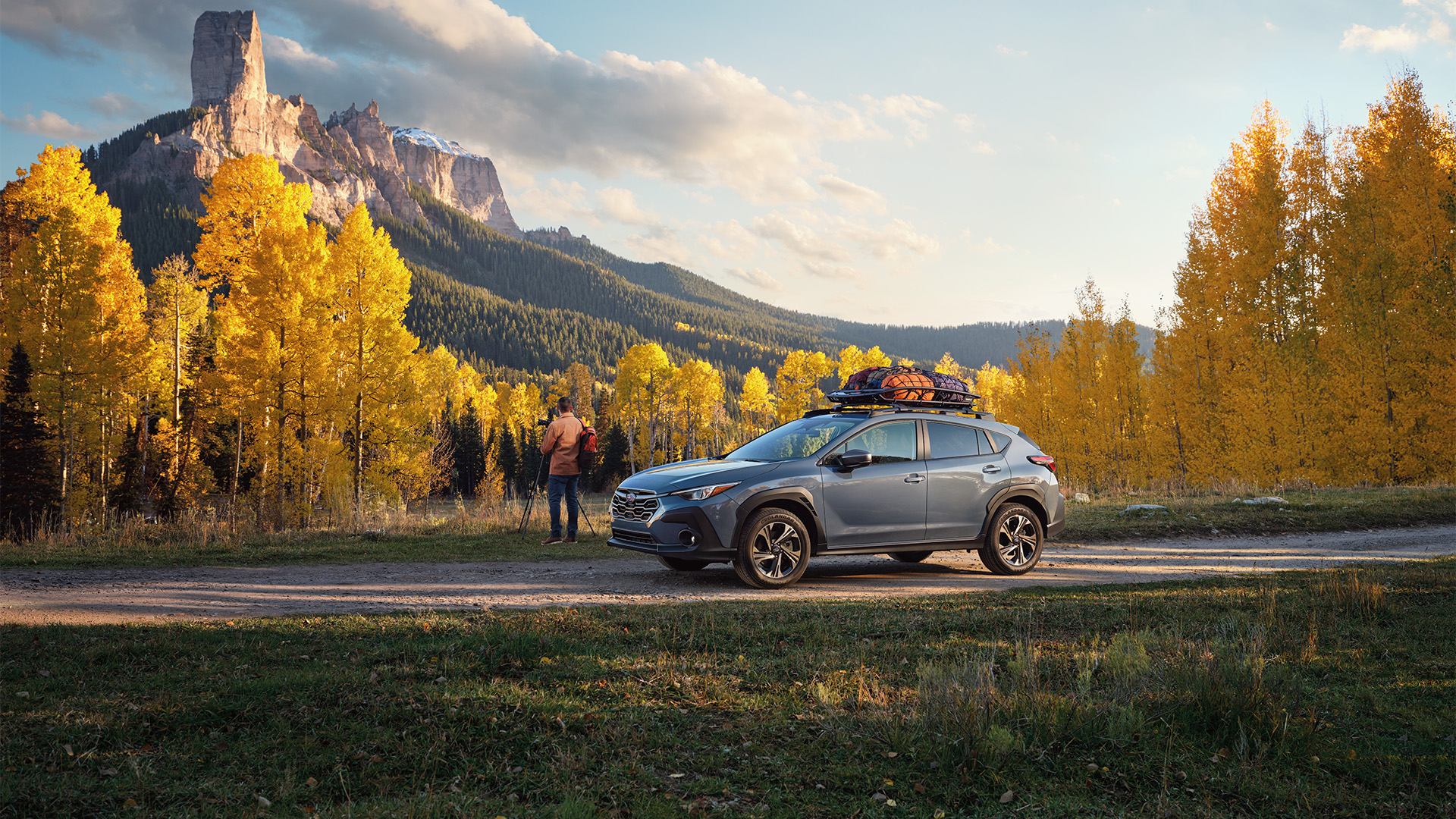 A 2025 Subaru Crosstrek navigating a scenic mountain path during sunrise
