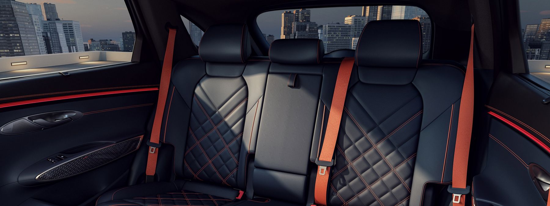 Rear interior of a Genesis GV70 with black quilted leather seats and orange seatbelts.