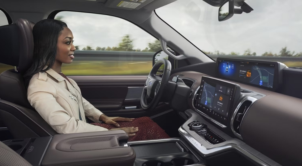Driver using Ford BlueCruise hands-free driving technology on a highway