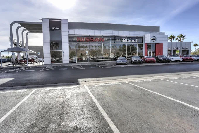 Planet Nissan dealership building with cars parked in front.
