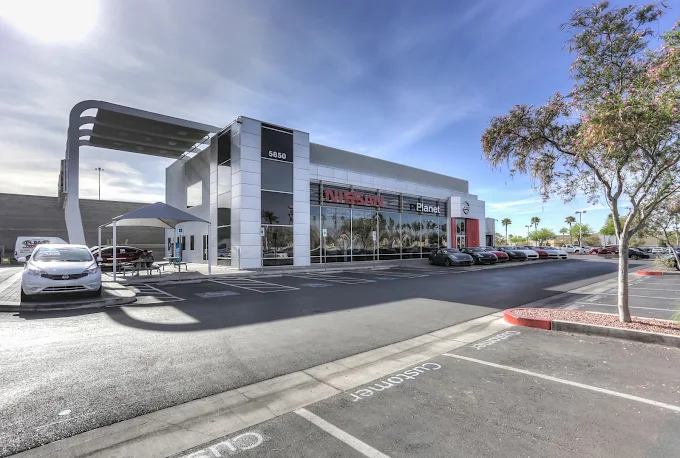 Nissan dealership exterior featuring modern architecture and car display.