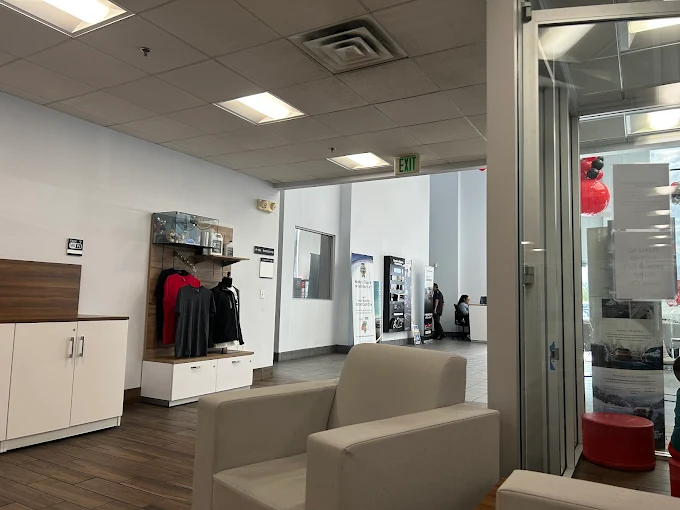 Dealership waiting area with white chairs and display.
