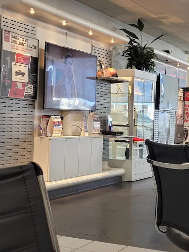 Waiting area with TV showing a man, brochures and products on display.