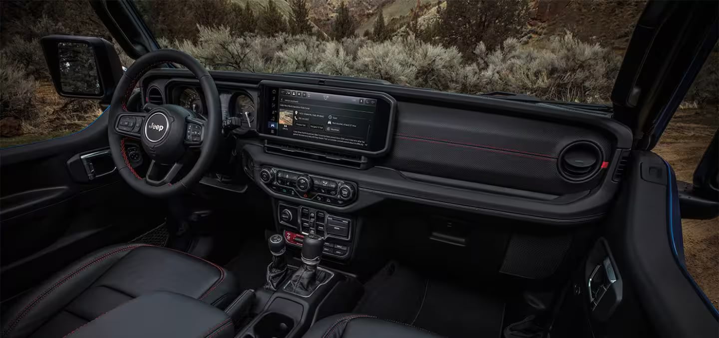 Interior view of a modern Jeep Wrangler showcasing the steering wheel, digital dashboard, and center console.