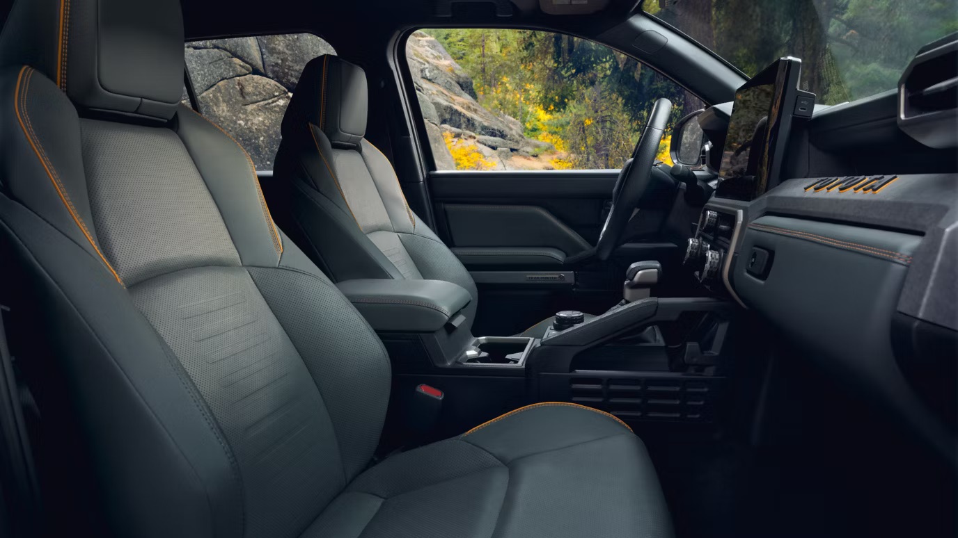 Interior view of a Toyota SUV featuring gray leather seats with orange stitching and a large infotainment screen.
