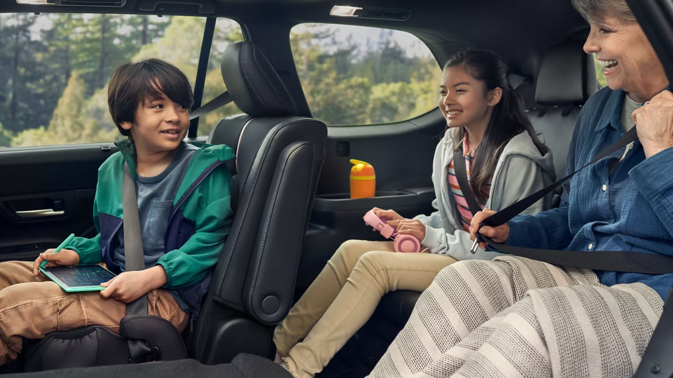 Family smiling during a road trip inside a spacious SUV.